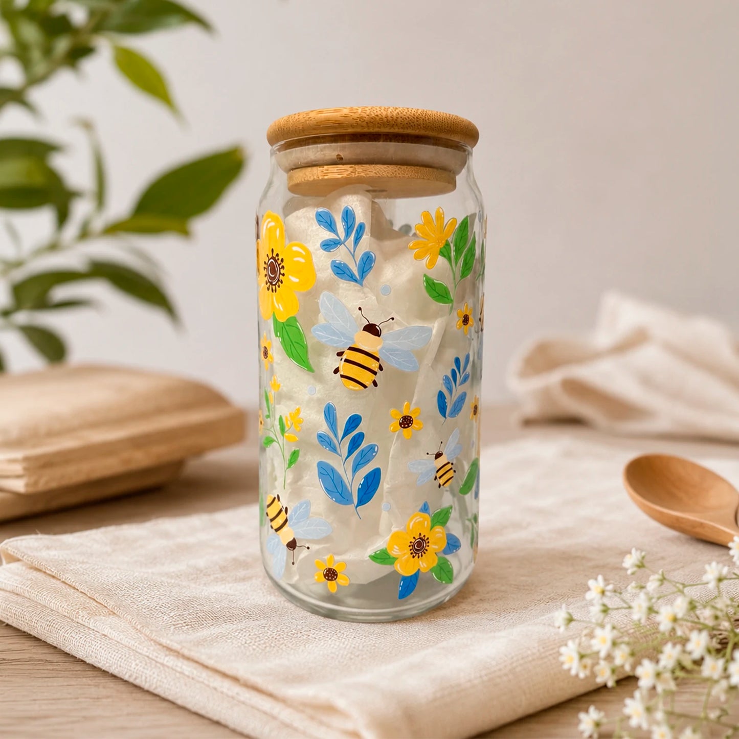 Vaso de vidrio transparente Flores y Abejitas 500 ml con tapa de bambú, bombilla de vidrio y diseño de flores amarillas, hojas azules y abejitas.