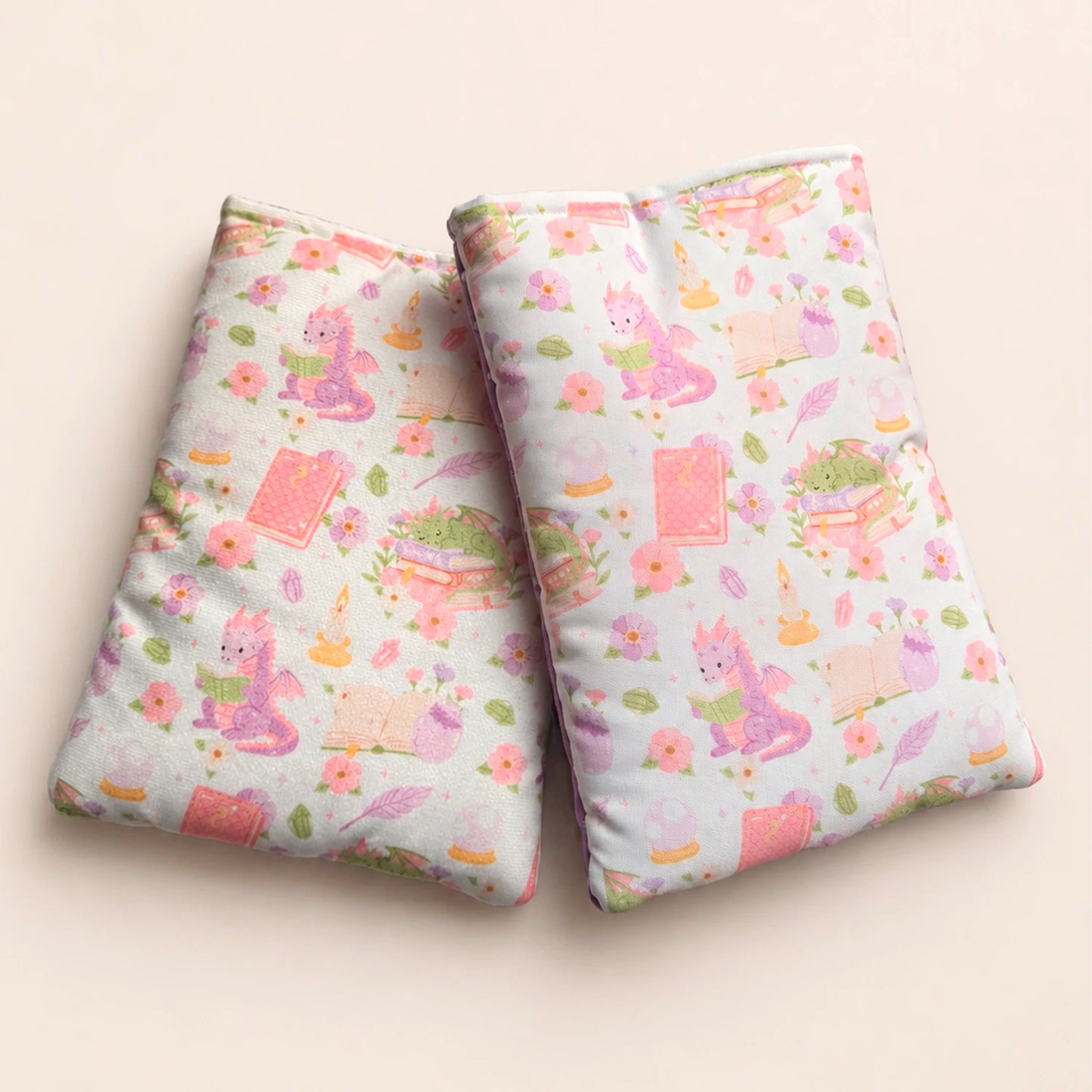 Funda literaria con estampado de dragón lector en tonos rosados y lilas para proteger libros