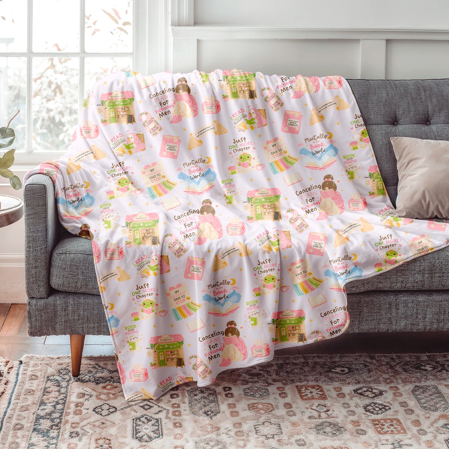 Manta de invierno inspirada en la vida de una lectora con diseño de libros, librerías, café y elementos literarios, confeccionada en felpa con reverso sherpa blanco.