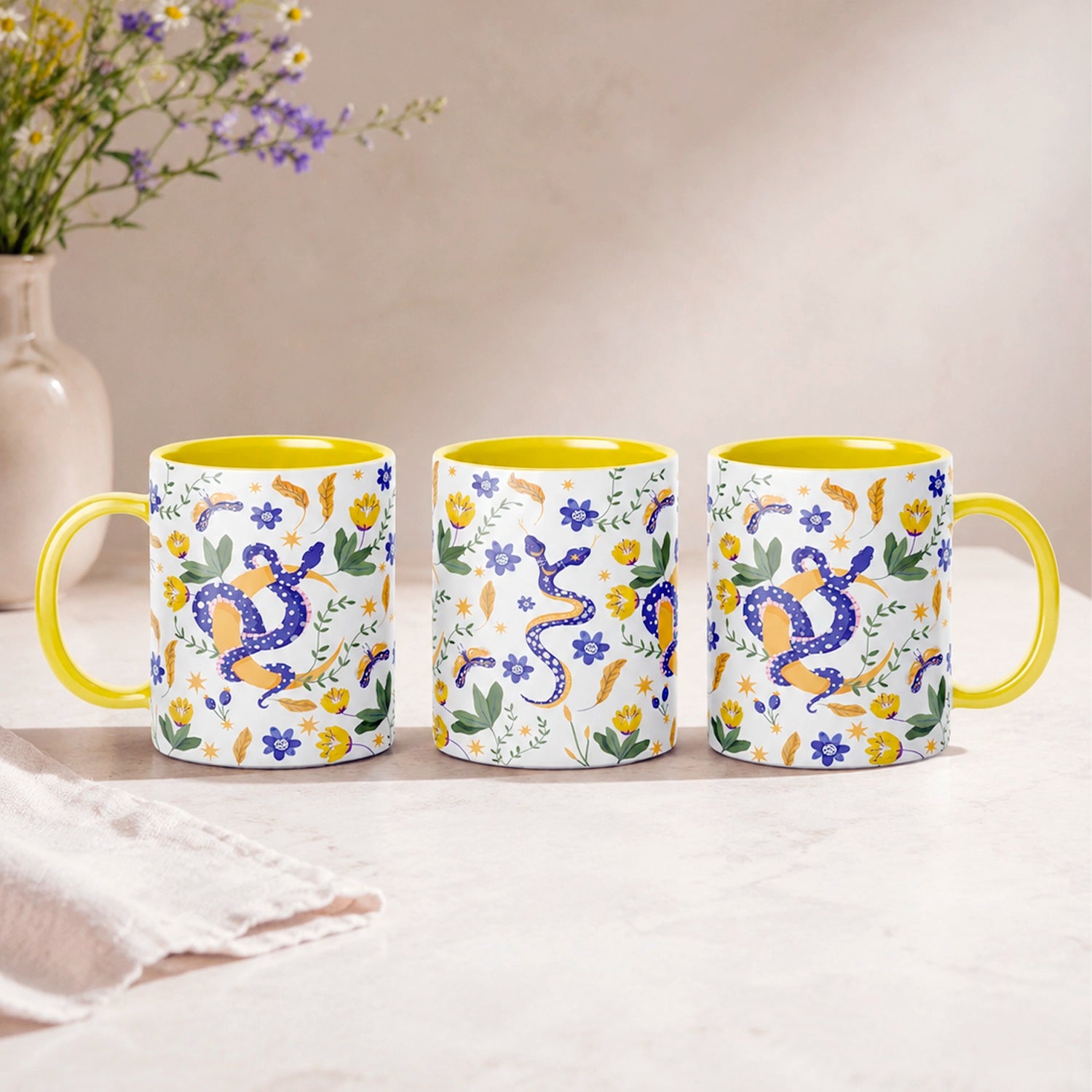 Taza sublimada de 325ml Encanto de Serpiente con asa e interior amarillo, diseño místico de serpientes azules, flores, hojas y detalles dorados.