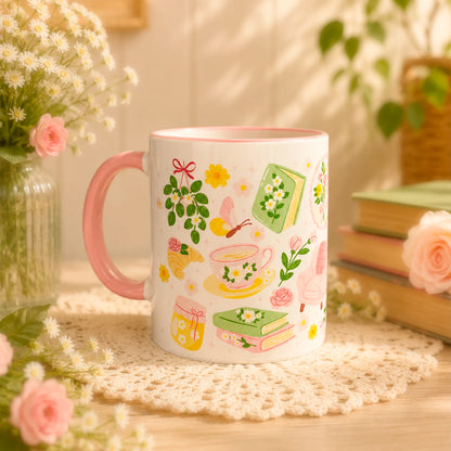 Taza literaria sublimada de cerámica 11 oz Jardín de Lectura con diseño delicado de flores, libros, sillón de lectura, taza de té y detalles rosados.