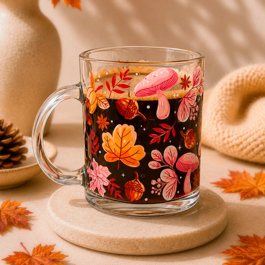 Taza de vidrio transparente 340 ml con diseño DTF UV de hojas otoñales, bellotas, hongos y flores en tonos naranjos y rosados.