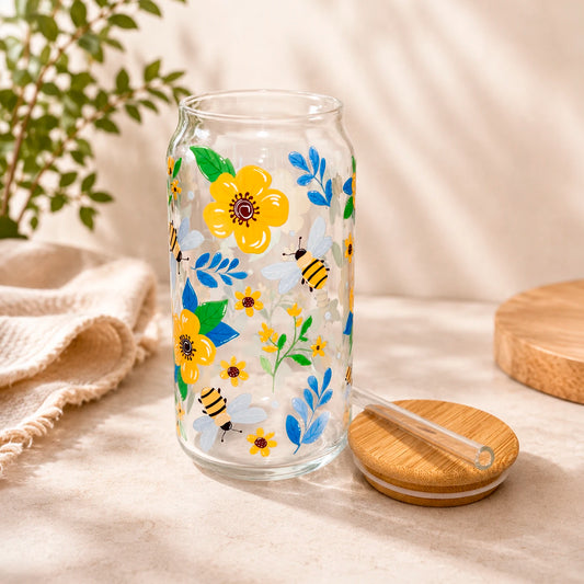Vaso de vidrio transparente Flores y Abejitas 500 ml con tapa de bambú, bombilla de vidrio y diseño de flores amarillas, hojas azules y abejitas.