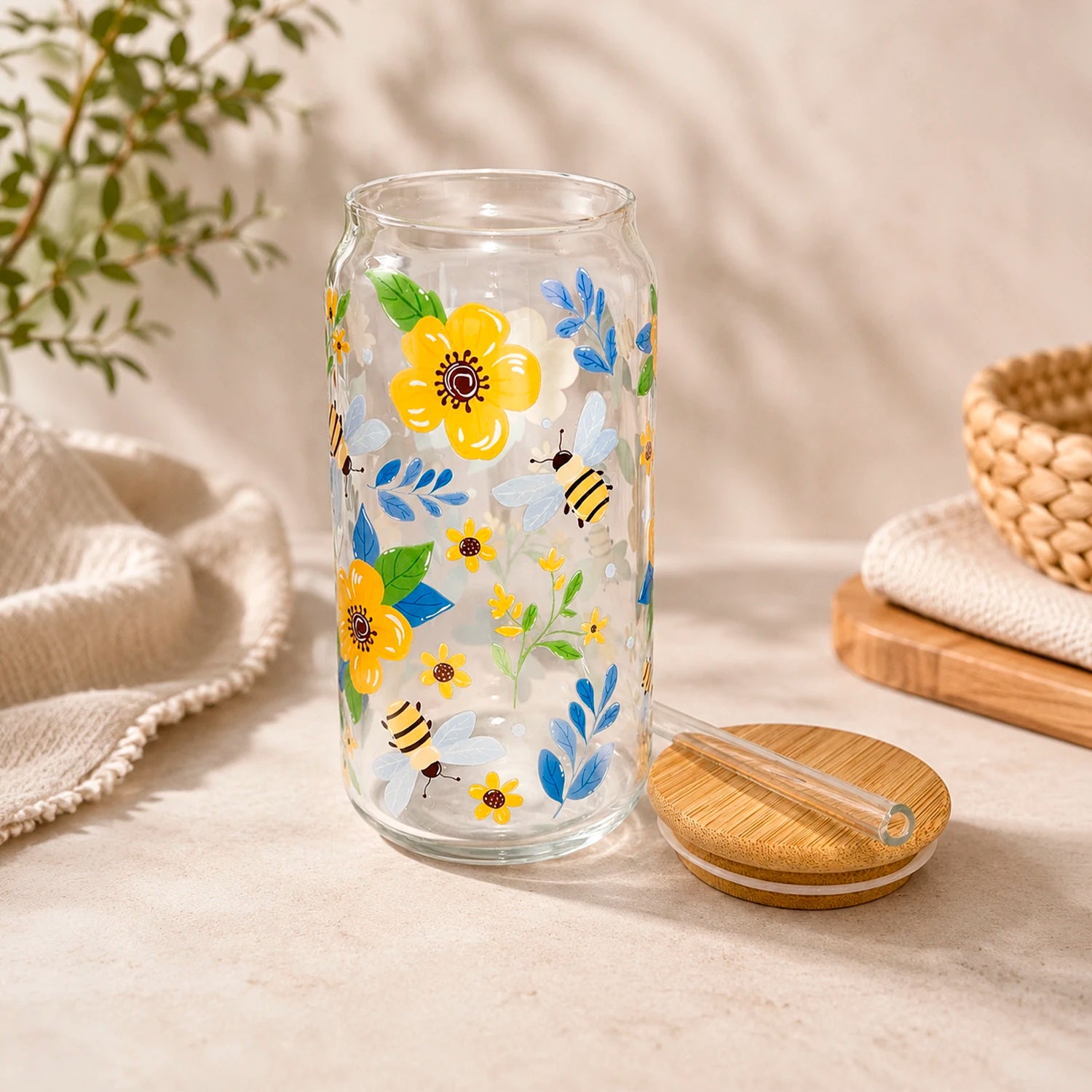 Vaso de vidrio transparente Flores y Abejitas 500 ml con tapa de bambú, bombilla de vidrio y diseño de flores amarillas, hojas azules y abejitas.