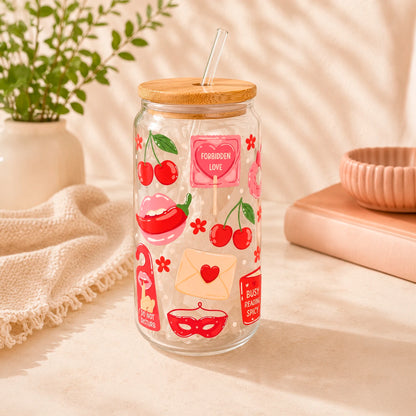 Vaso de vidrio transparente Spicy Reader 500 ml con tapa de bambú, bombilla de vidrio y diseño romántico con cerezas, corazones, antifaz, libros y detalles rojos.